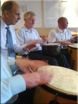 A group learning to work together whilst having fun finding out how to drum.